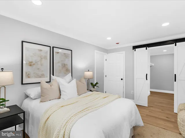 a bedroom with a bed and a painting on the wall