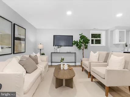 a living room with furniture a potted plant and a view of kitchen