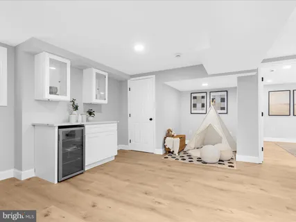 a view of a kitchen with white cabinets and wooden floor