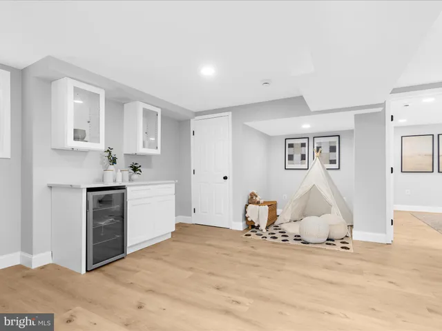 a view of a kitchen with white cabinets and wooden floor