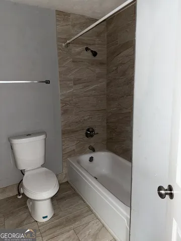 a bathroom with a toilet and a shower