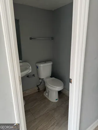 a white toilet sitting next to a small sink