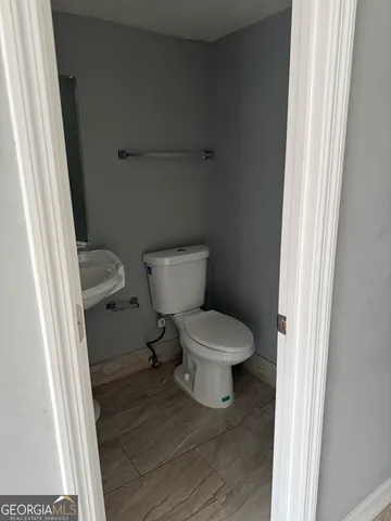 a white toilet sitting next to a small sink