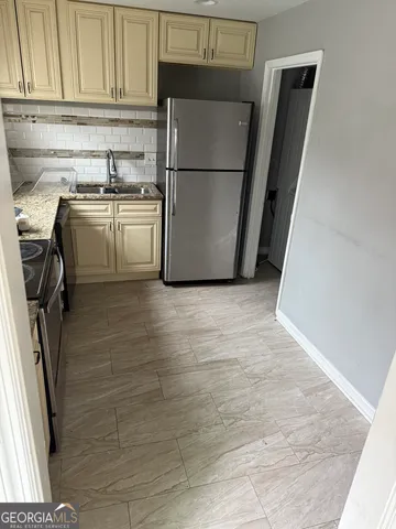 a kitchen with a refrigerator sink and cabinets