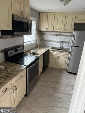 a kitchen with cabinets stainless steel appliances and a counter space
