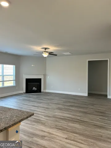 an empty room with wooden floor and fireplace