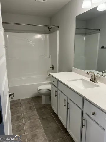 a bathroom with a granite countertop sink toilet a mirror and shower