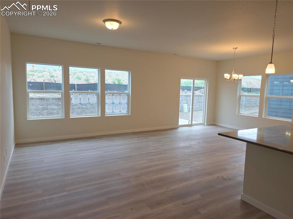 5356 Truscott Road Colorado Springs, CO 80925 - Photo 3 of 16 an empty room with wooden floor and windows