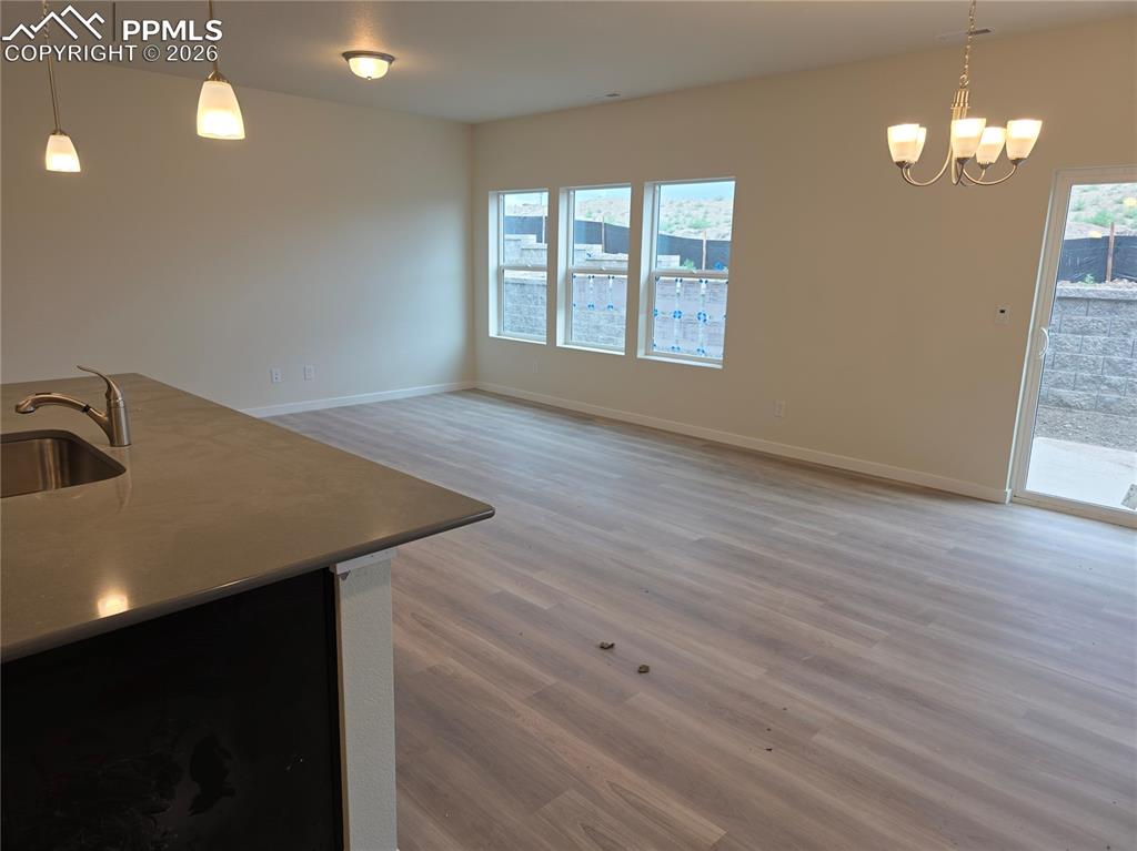5356 Truscott Road Colorado Springs, CO 80925 - Photo 6 of 16 wooden floor in an empty room with a window