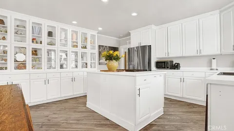 a kitchen with stainless steel appliances granite countertop a refrigerator oven a sink dishwasher and white cabinets with wooden floor