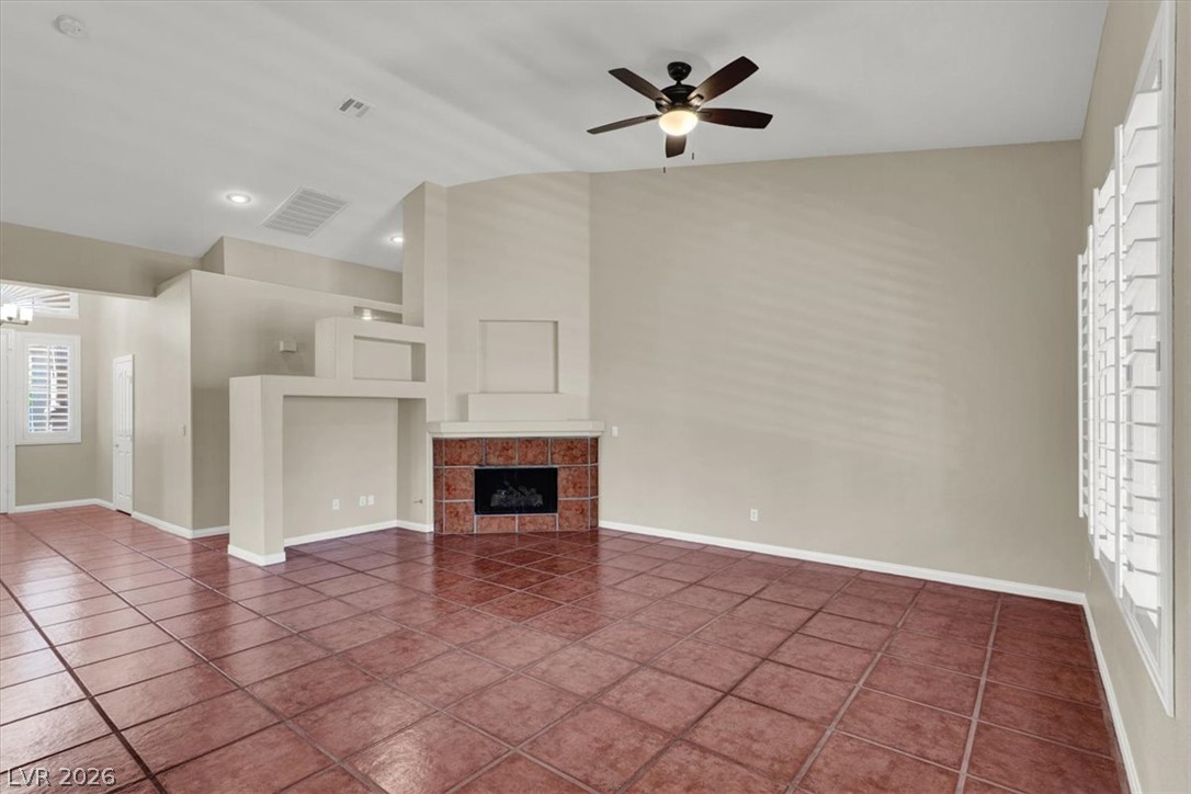 7308 Rustic Meadow Street Las Vegas, NV 89131 - Photo 9 of 27 A spacious common area offers rich terracotta tile flooring and a decorative corner fireplace.