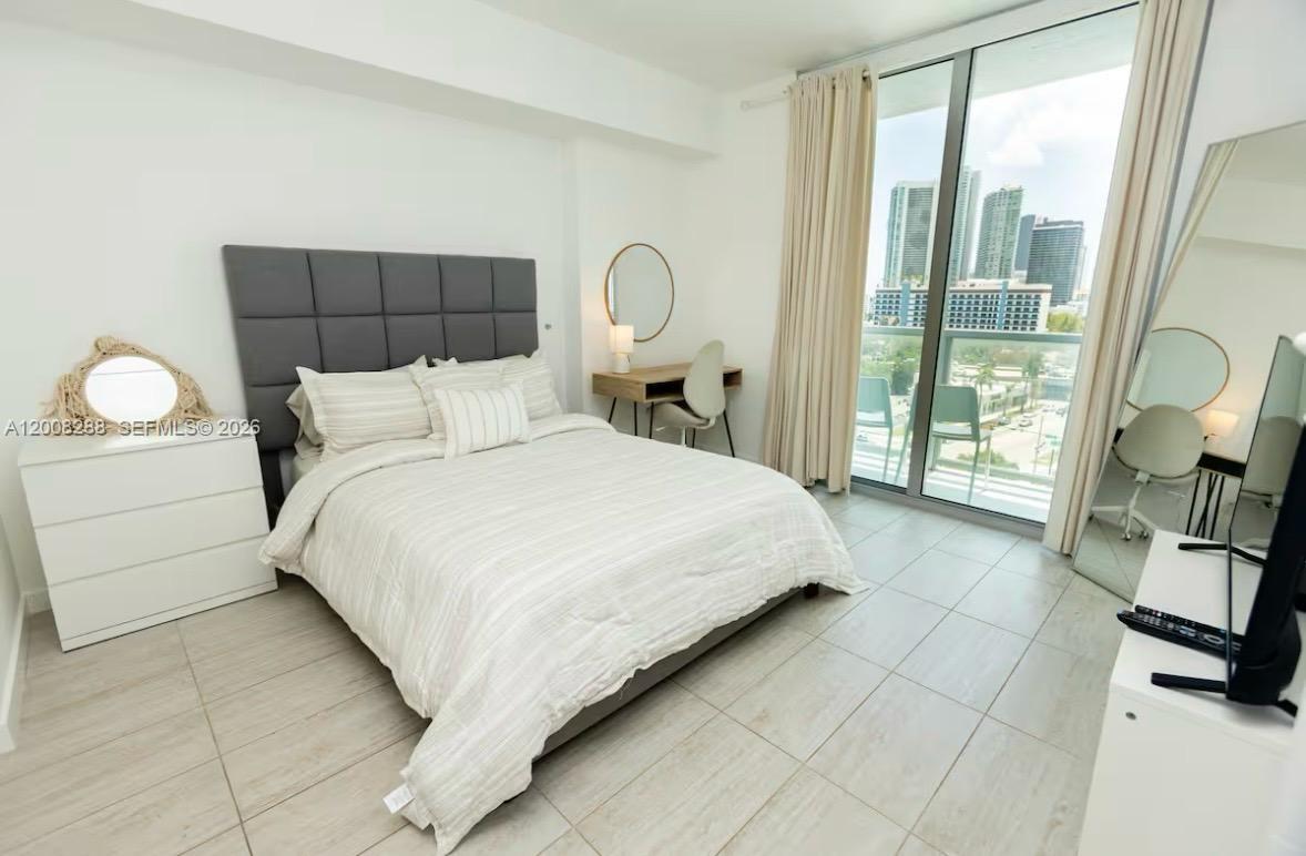 3900 Biscayne Boulevard, Unit S906 Miami, FL 33137 - Photo 5 of 17 a bedroom with a bed window and mirror