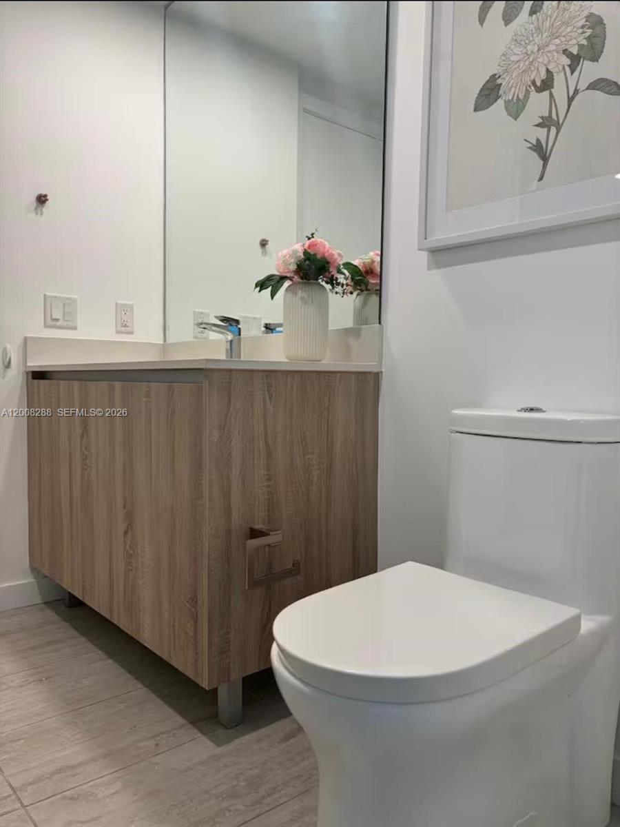 3900 Biscayne Boulevard, Unit S906 Miami, FL 33137 - Photo 7 of 17 a bathroom with a white toilet and vanity