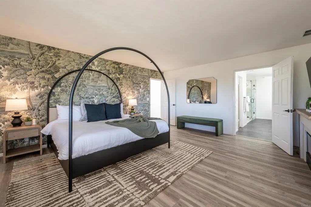 26086 Bear Valley Heights Road Valley Center, CA 92082 - Photo 42 of 65 a spacious bedroom with a large bed and a wooden floor