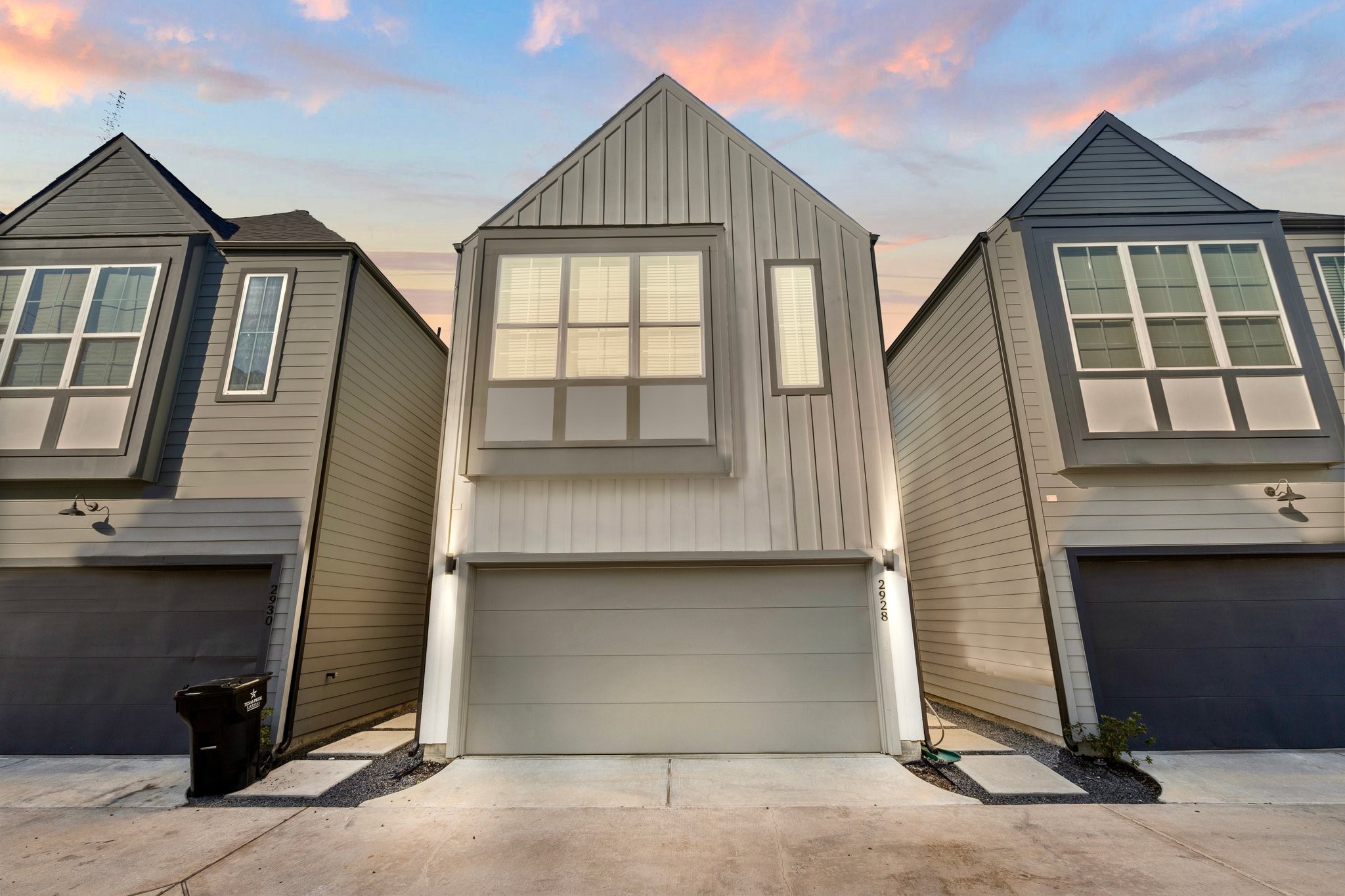 2928 Stevens Street Houston, TX 77026 - Photo 1 of 30 Modern two-story townhouse with a sleek facade and large front windows. It features a double garage and is situated in a row of similar homes. The setting provides a cozy, urban neighborhood feel.