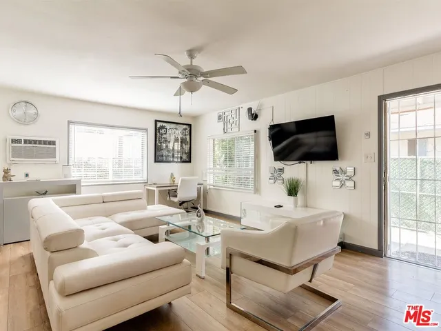 a living room with furniture a flat screen tv and a large window