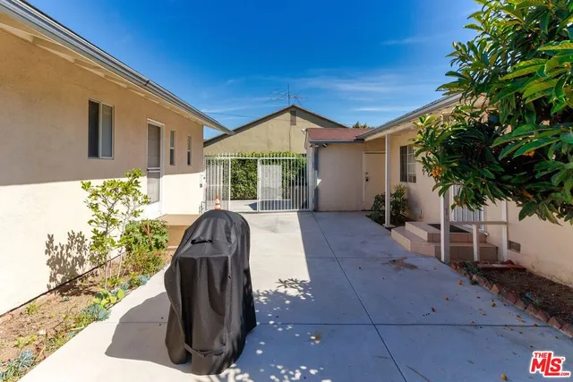 a view of backyard with potted plants and wooden fence