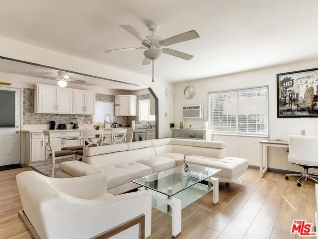 a living room with furniture and view of kitchen