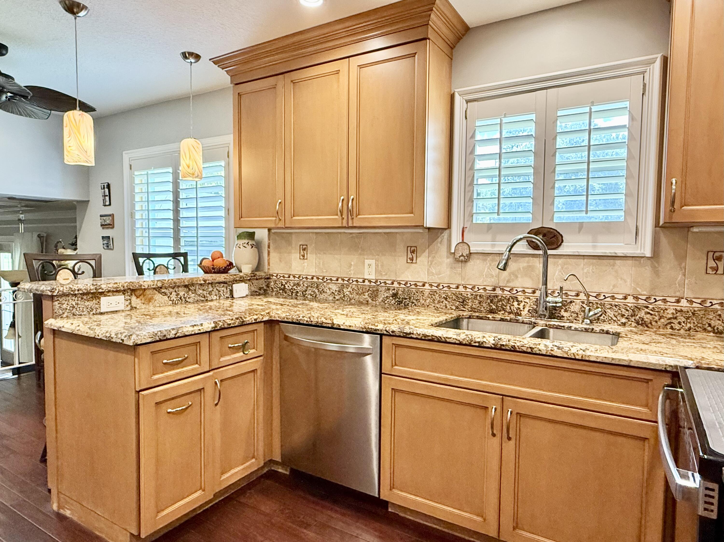16283 Alexander Run Jupiter, FL 33478 - Photo 23 of 96 a kitchen with kitchen island granite countertop a sink appliances cabinets and a large window