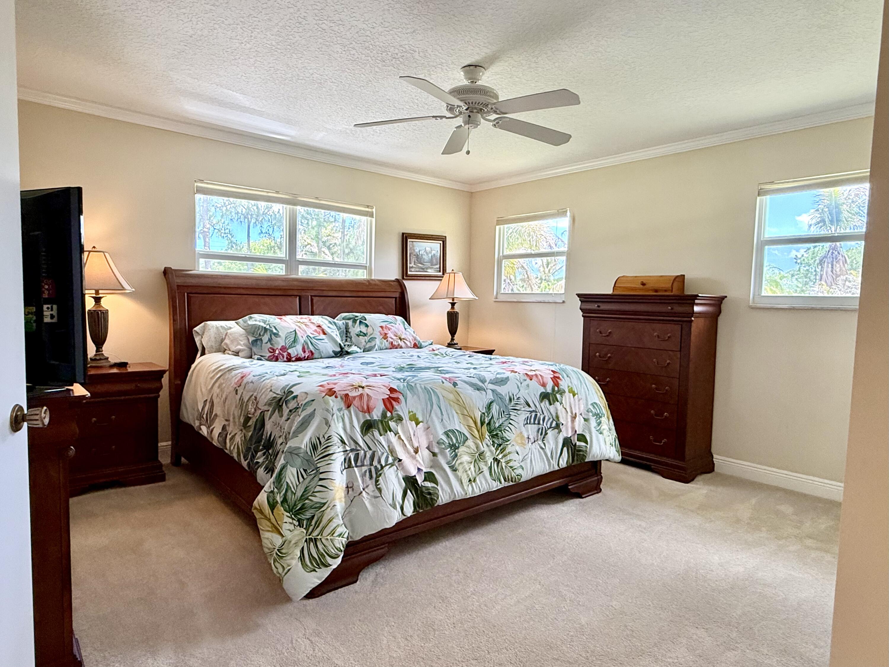 16283 Alexander Run Jupiter, FL 33478 - Photo 38 of 96 a bedroom with a bed and wooden floor