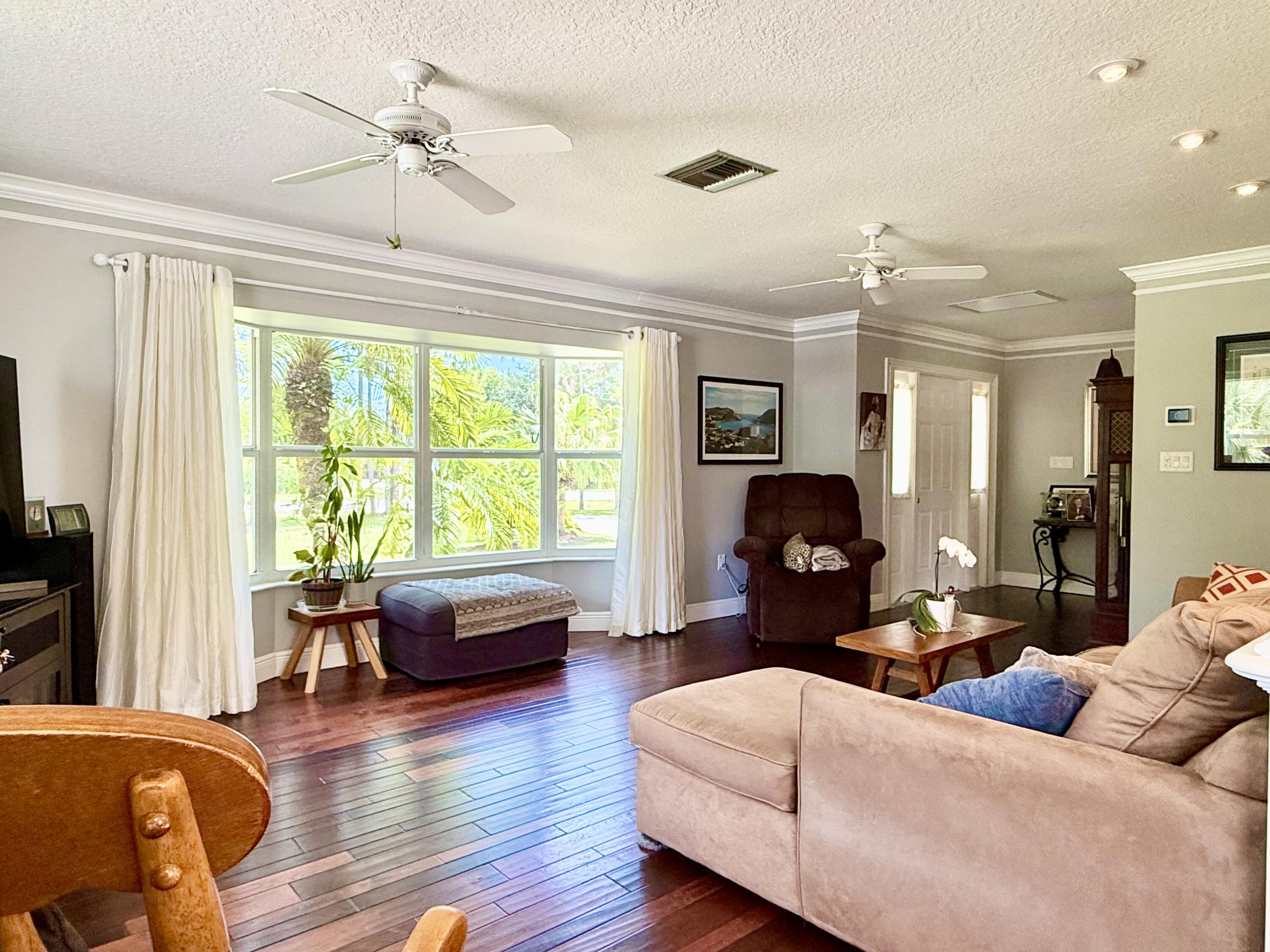 16283 Alexander Run Jupiter, FL 33478 - Photo 4 of 96 a living room with furniture and wooden floor