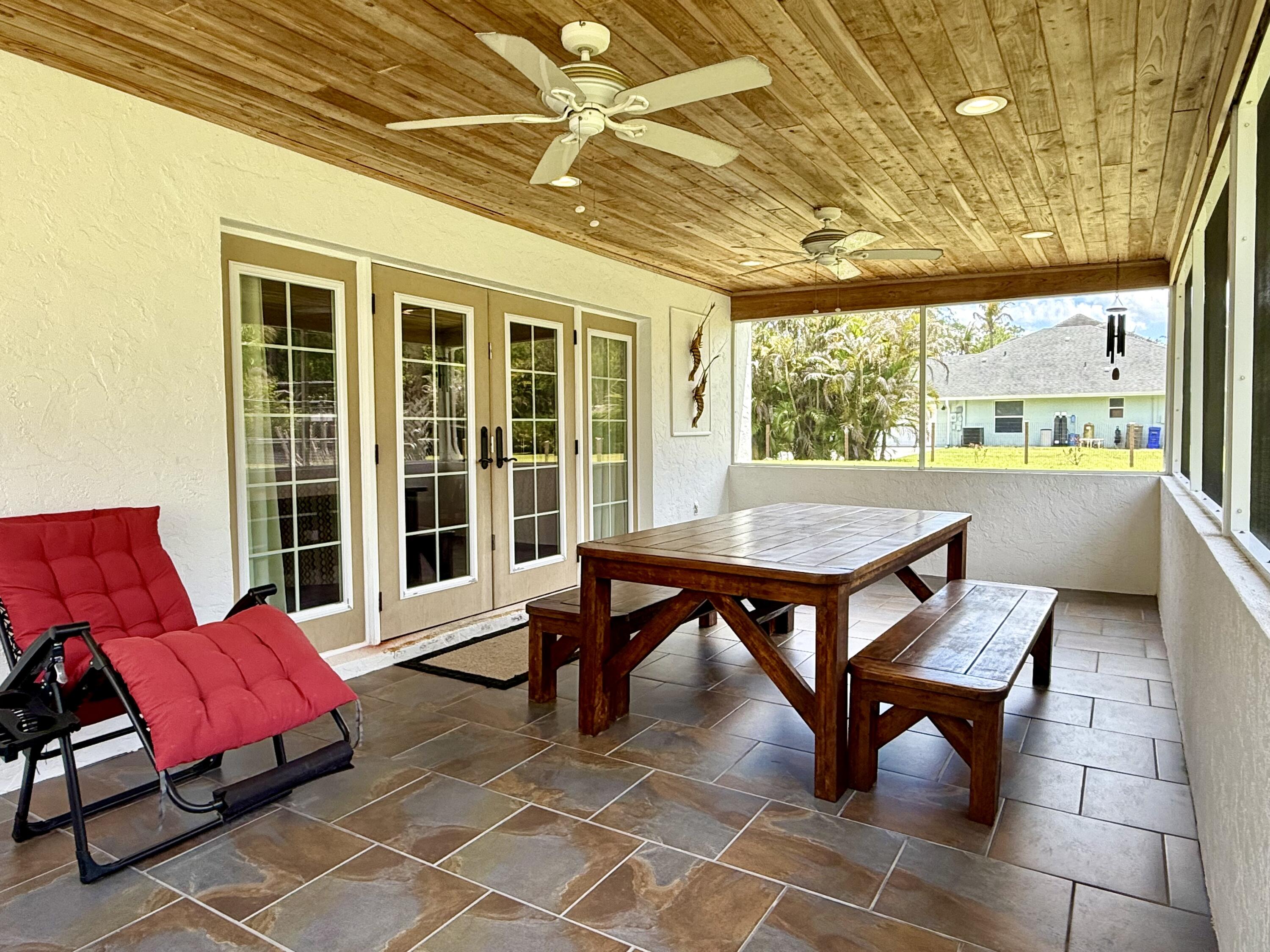16283 Alexander Run Jupiter, FL 33478 - Photo 55 of 96 a balcony with wooden benches and a couch