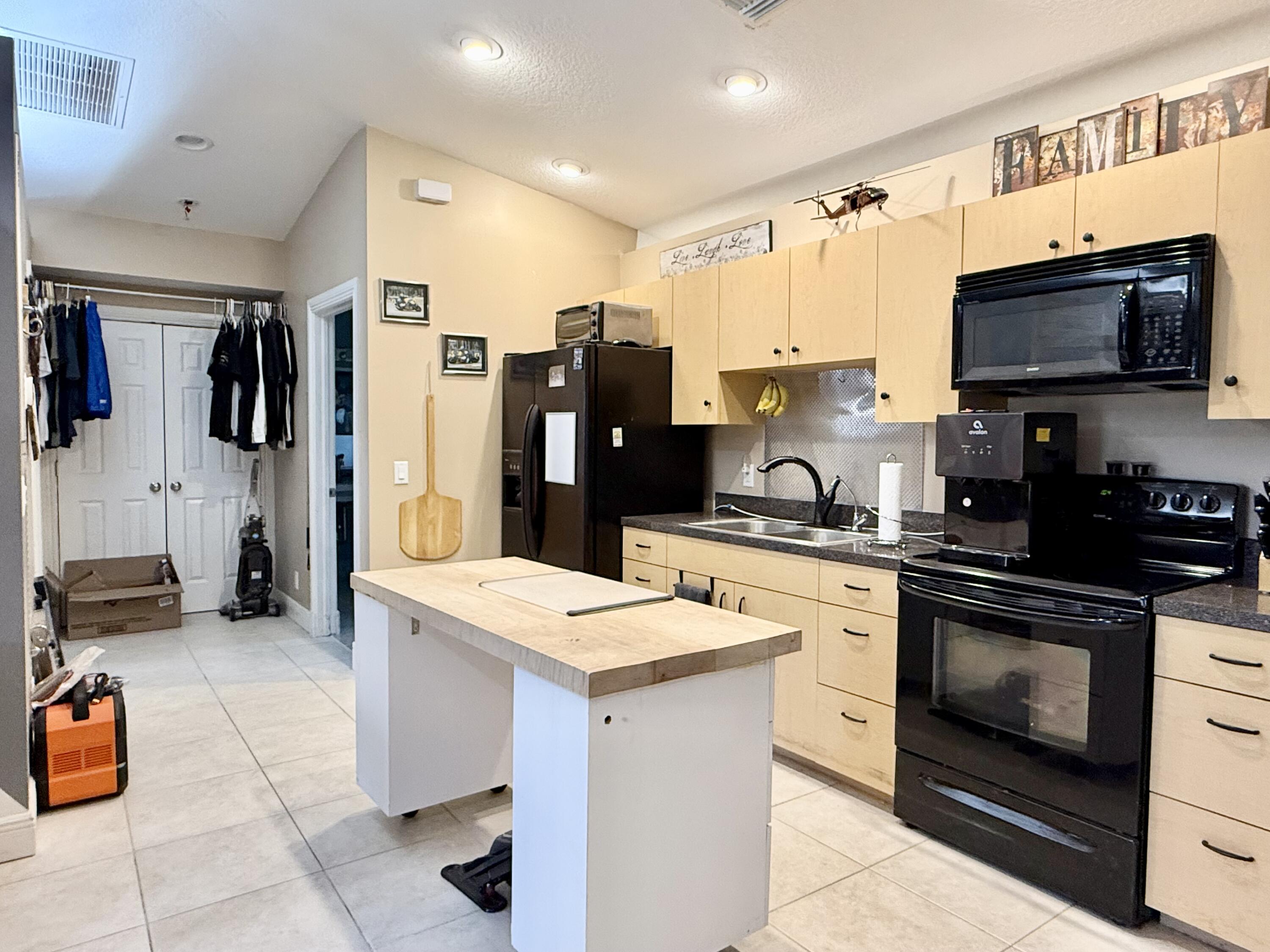 16283 Alexander Run Jupiter, FL 33478 - Photo 62 of 96 a kitchen with stainless steel appliances granite countertop a stove top oven a sink dishwasher and a refrigerator with the cabinets