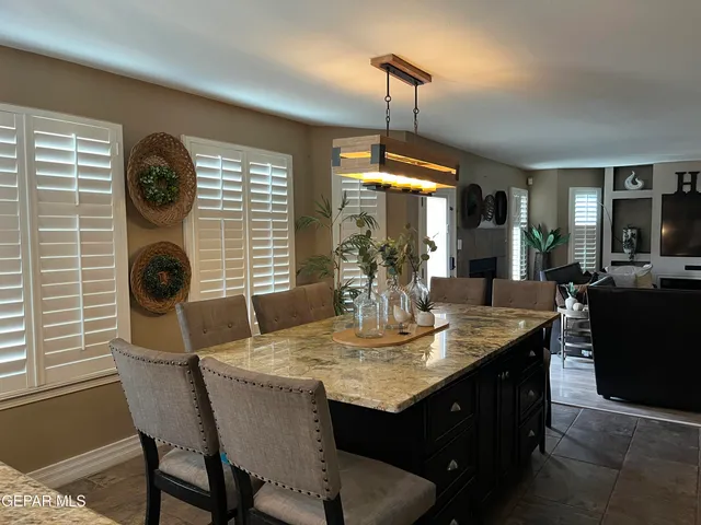a kitchen with a table chairs and granite counter tops