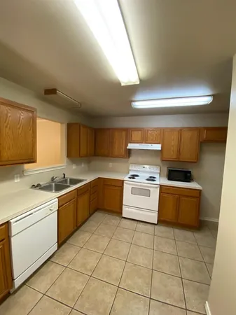 a kitchen with stainless steel appliances a stove a sink and white cabinets