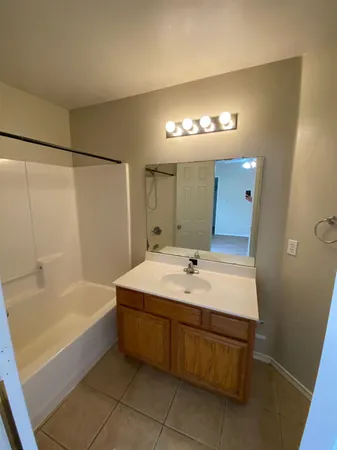 a bathroom with a tub sink and mirror