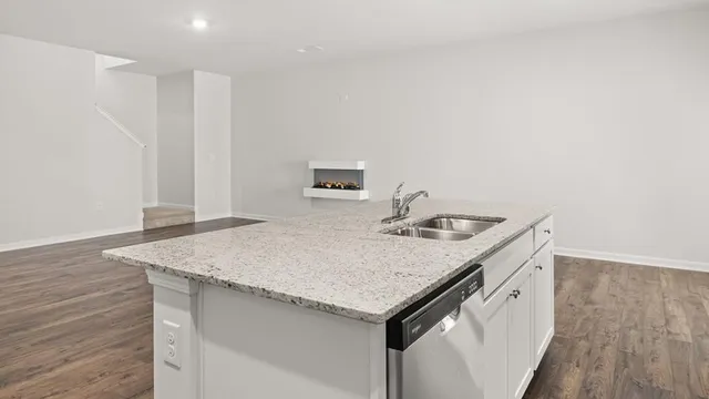 a kitchen with a sink a microwave and wooden floor