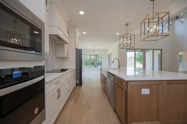 an empty room with wooden floor and chandelier