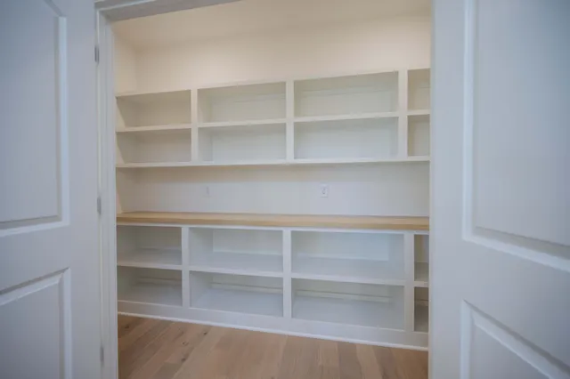 a view of a big room with wooden floor and windows