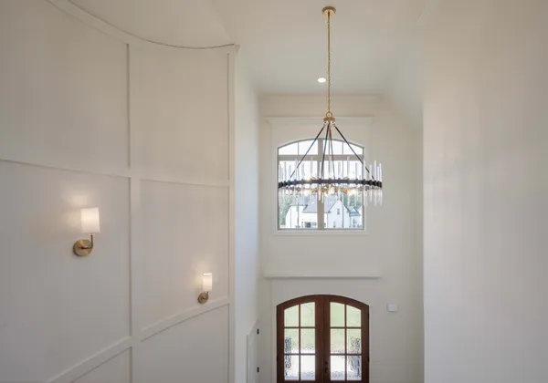a view of staircase with railing and a chandelier