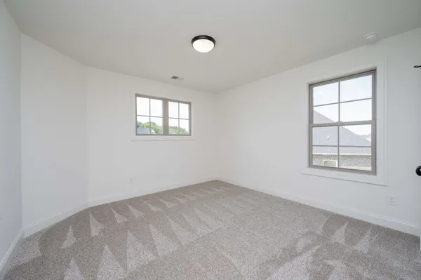 an empty room with a fireplace and windows