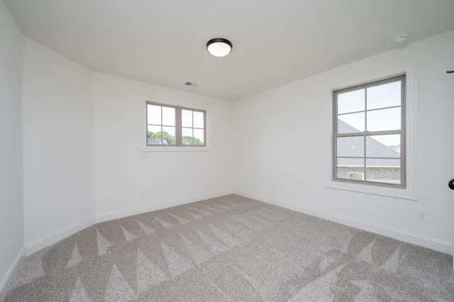 an empty room with a fireplace and windows