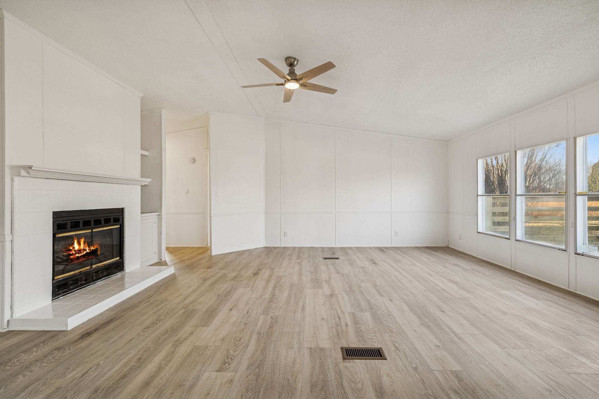 145 Milk Barn Road Cookeville, TN 38506 - Photo 6 of 43 an empty room with wooden floor fireplace and windows