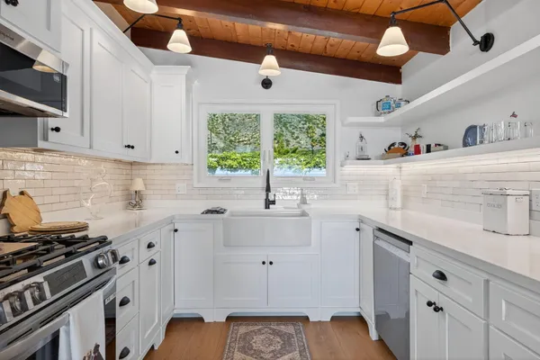 a kitchen with stainless steel appliances a stove a sink and a microwave