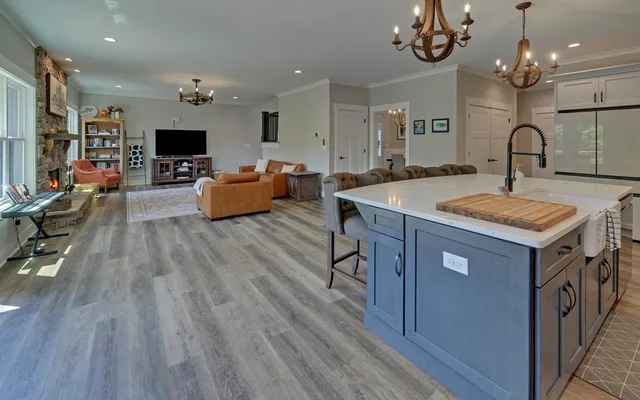 a kitchen with a sink stove cabinets and wooden floor