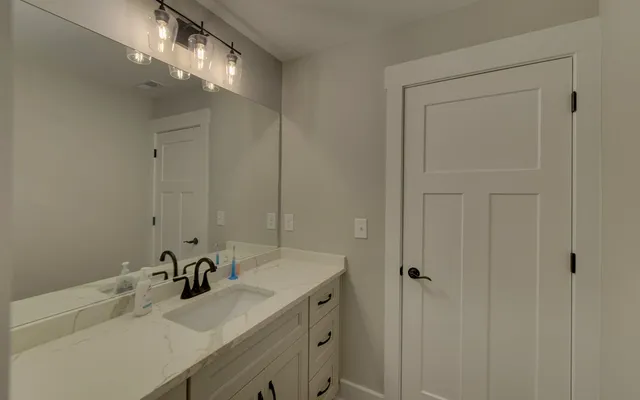 a bathroom with double vanity sink and a mirror