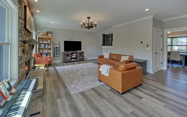 a kitchen with stainless steel appliances granite countertop a stove top oven a sink dishwasher and white cabinets with wooden floor