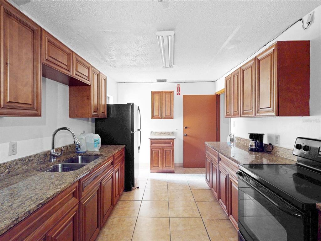 3425 Forsyth Road Winter Park, FL 32792 - Photo 22 of 40 a kitchen with stainless steel appliances granite countertop a sink stove and refrigerator