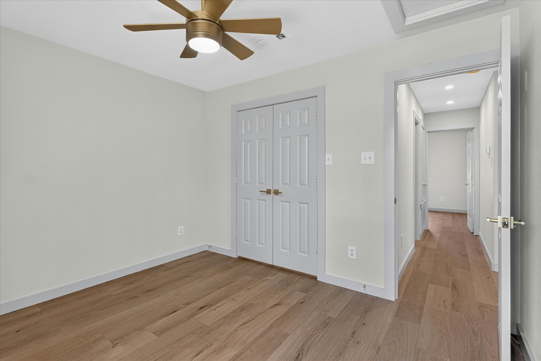 258 Pine View Loop Bastrop, TX 78602 - Photo 34 of 40 A well-lit room showcases rich hardwood flooring and a stylish ceiling fan, promising comfort.