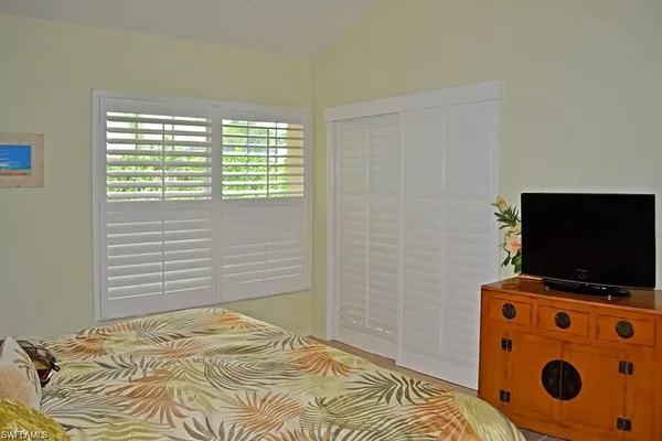 a bedroom with a bed and flat screen tv