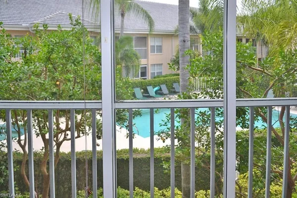 a view of a house with a floor to ceiling window and tree