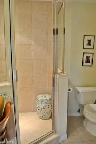 a bathroom with a granite countertop shower and a toilet
