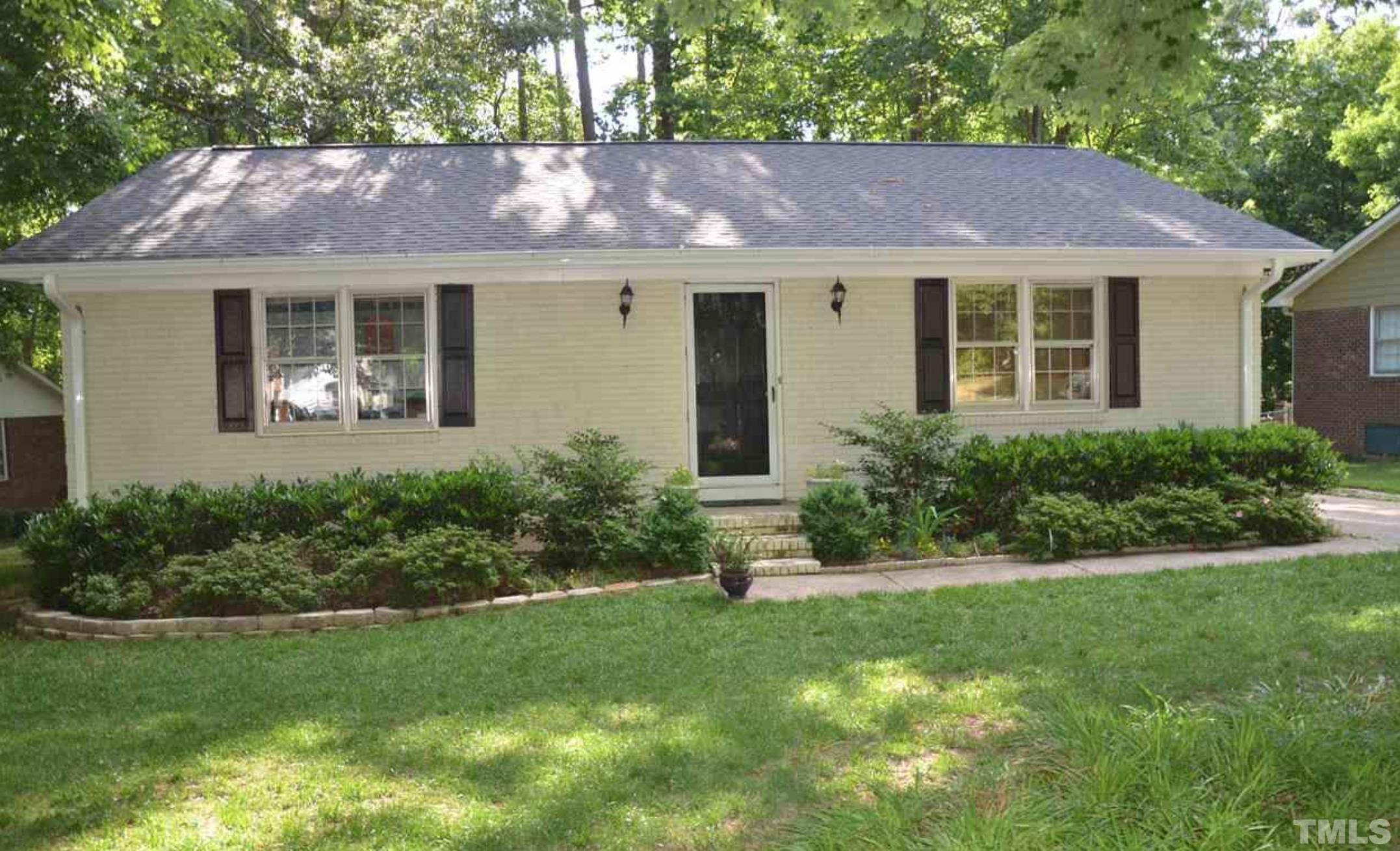 a front view of a house with a yard and glass windows