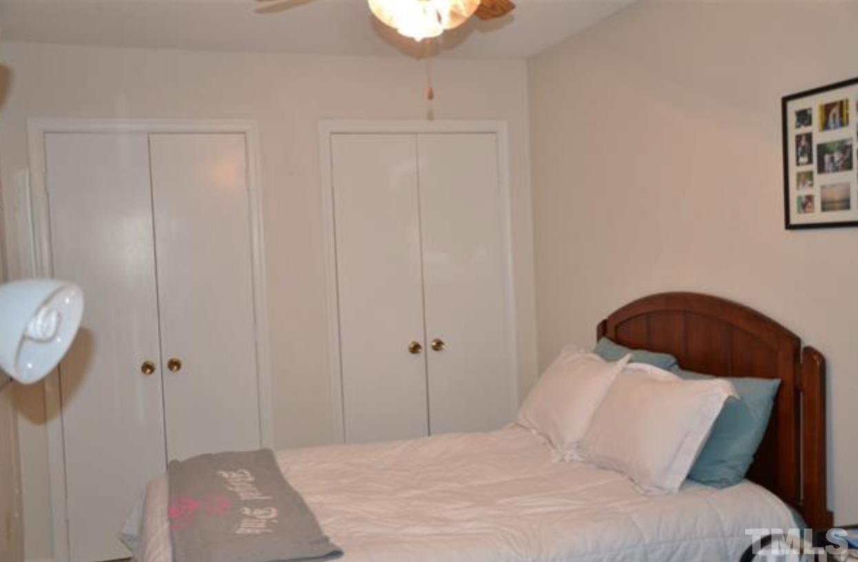 7809 Hemlock Court Raleigh, NC 27615 - Photo 12 of 16 a bedroom with a bed and a potted plant