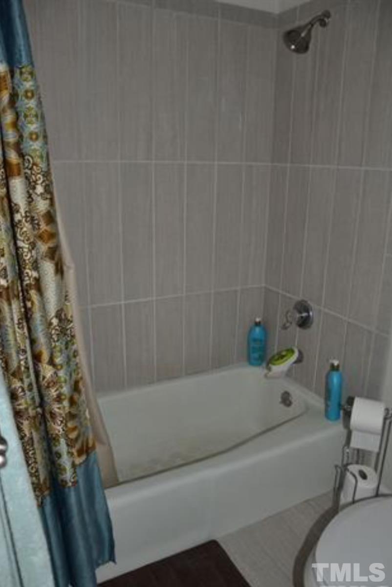 7809 Hemlock Court Raleigh, NC 27615 - Photo 15 of 16 a bathroom with a bathtub and shower