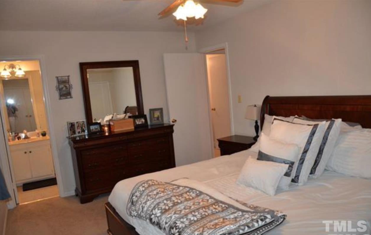 7809 Hemlock Court Raleigh, NC 27615 - Photo 8 of 16 a bedroom with a bed and a chandelier